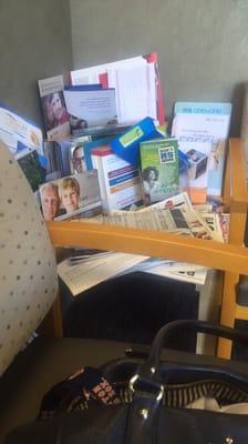 The over filled side table in the waiting area.