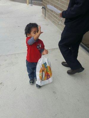 He's so friendly! He's waiving good bye to the people walking out the library