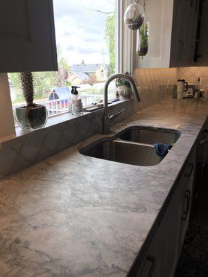 Super white granite in kitchen and area his installers touched up the caulking.