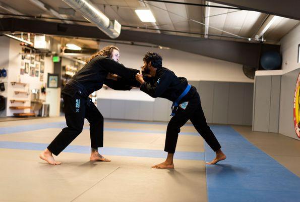 Professor Shae demonstrates a collar grip with a student.