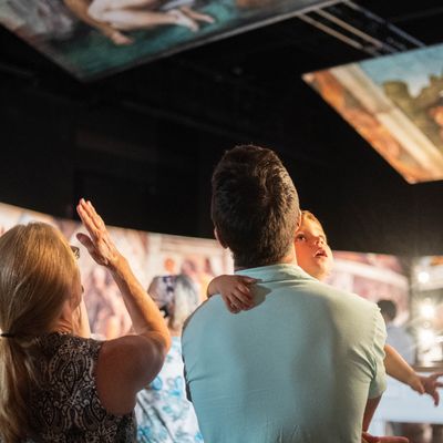 Man, woman, baby enjoying Michelangelo's Sistine Chapel: The Exhbition