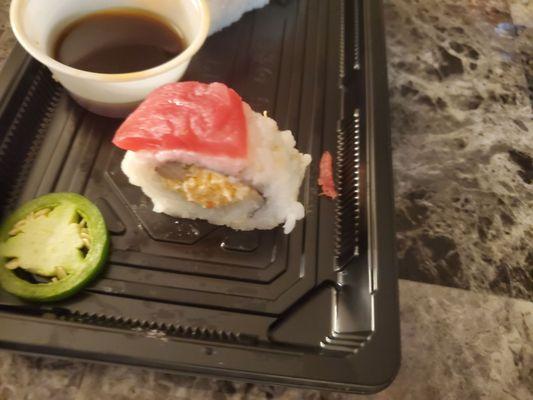 Spanish fly roll has tiny piece of yellow tail in the top left corner and a tiny sliver of tuna on top. Jalapeno removed to show fish.