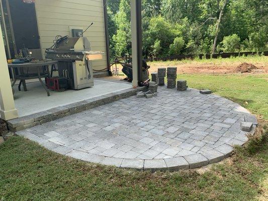 Paver patio final stones being cut and laid in