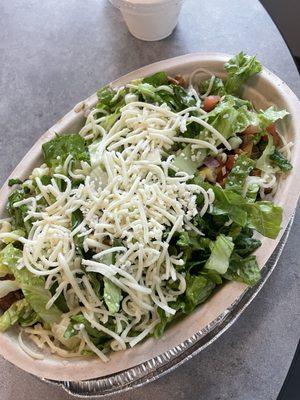 Chicken bowl with brown rice, lettuce, cheese, pico, and corn.