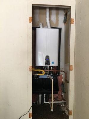 Navien, high efficiency condensing tankless water heater, installed in a garage closet