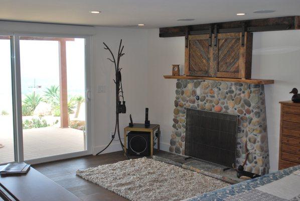 Rock clad fireplace and barn door style tv cabinet