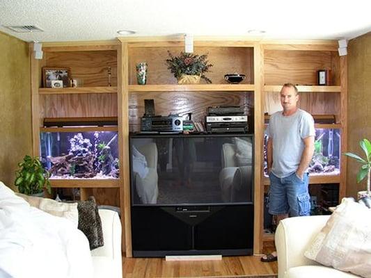 Custom oak wall unit built around TV, with two fish tanks incorporated into the design.