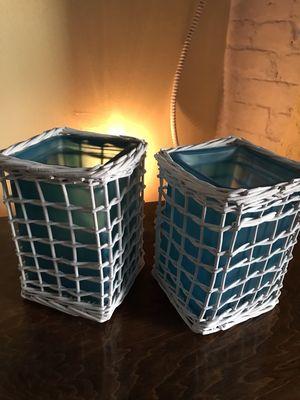 Turquoise colored glass candle holder with white wicker outside of glass