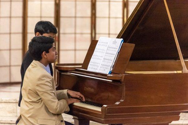 Young piano student plays in an end of year recital.