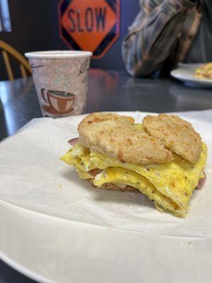 Delicious Ham, bacon, and cheese on a biscuit  and a great cup of coffee