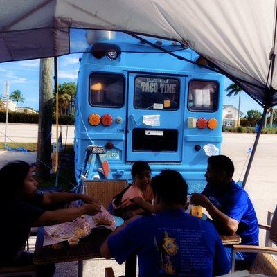 The "Taco Time" bus in the parking lot of El Corazon de Mexico Latin Food & Market.