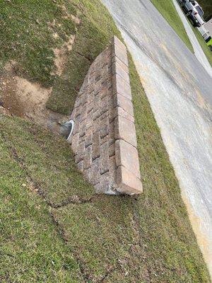 Newly constructed decorative brick/paver retaining wall on both sides of driveway.