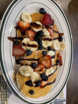 Pancake with chocolate syrup and fruits.