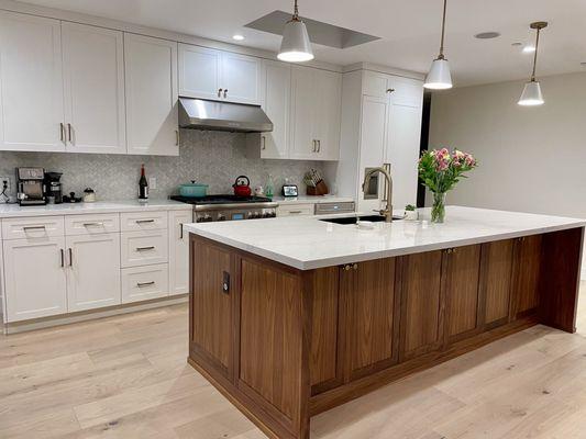 Walnut island and white shaker kitchen cabinets.