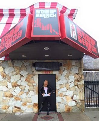 The Queen of New York Ave, Ms. Britney Shannon out front of the newly-hung Strip Search sign.