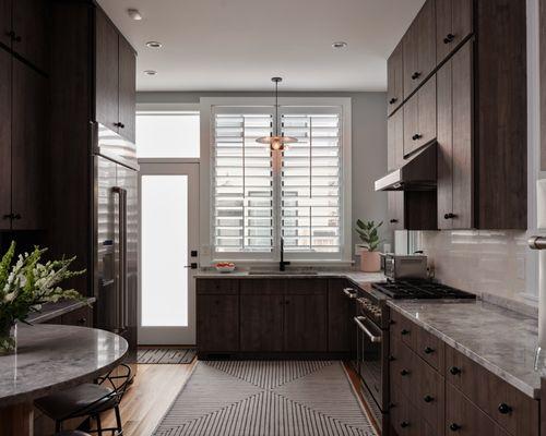 Larger 3.5" louvers on  plantation shutters help maximize the light nicely in this Fan neighborhood kitchen.