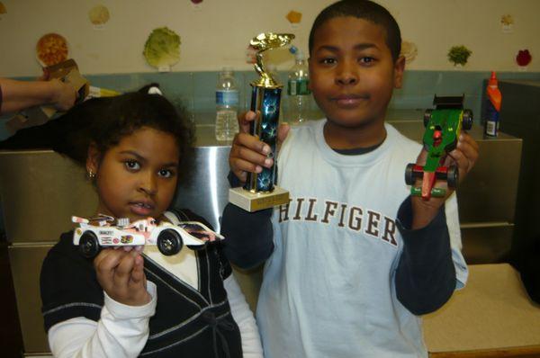 Joel and Selena Allen Pinewood derby Racing Winters with two of the cars the kids put together.