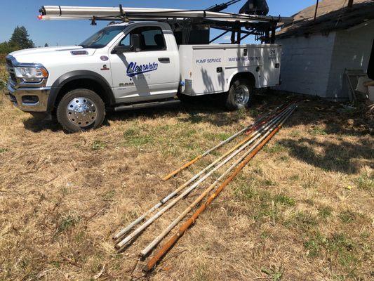 Old pipe on the ground. New pipe on the truck.