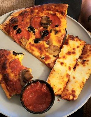 Medium sized pepperoni, mushrooms and black olive pizza with cheese bread.