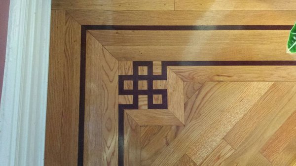 Brand new installation of a white oak floor on a diagonal with a double walnut border with corner blocks in all corners of the rooms.