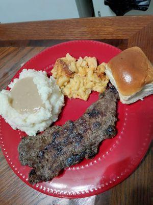 Strip steak, mash potatoes, gravy, mac-n-cheese and a dinner roll