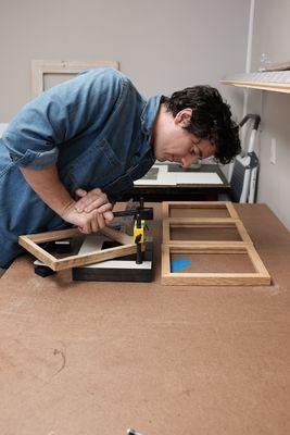 Assembling a series of frames in the framing room of Cove Creative.