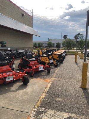 Bad boy (orange) and Cub Cadet (yellow) riding and zero turn riding mowers