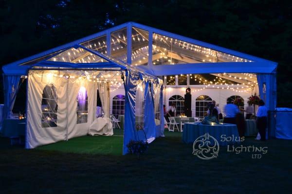 String lights hung for general illumination in a tent for a graduation party.