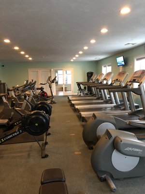 Upstairs cardio room with treadmill, stair climbing, and rowing machines.