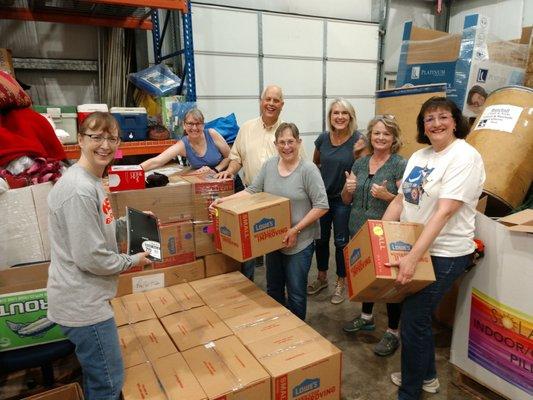 Hearty volunteers and staff sorting School SmilePacks