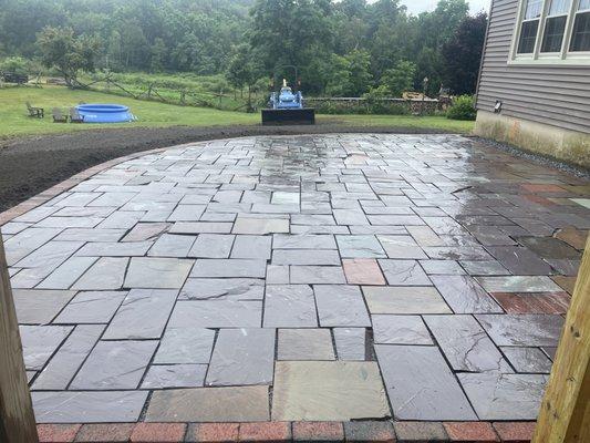 Locally-sourced slate patio and brick border.