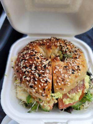 Everything bagel custom sandwich with sausage, mashed avocado, tomato, sprouts and microgreens