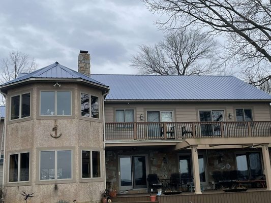 Protecting this home from harsh water-front winds is a  freshly installed Corrugated Metal Roofing System painted in "Ocean Blue".