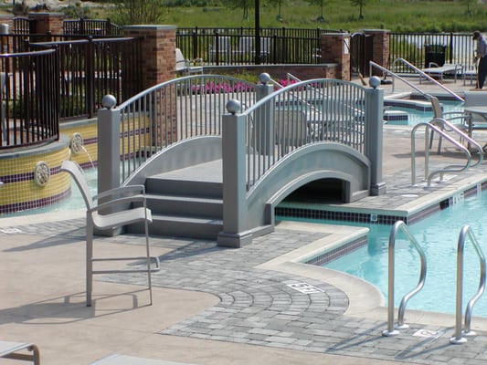 Designed & built by J & J Aquatics, this pool features a covered bridge and custom water features.