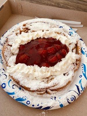 funnel cake with powdered sugar, strawberry, and whipped cream