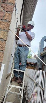 Installing a camera on the side of a customer's home in Brooklyn New York.