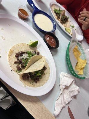 Chips with cheese dip and salsa and steak tacos