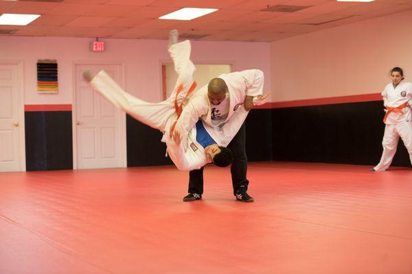 Adult class performing one-arm shoulder throw.