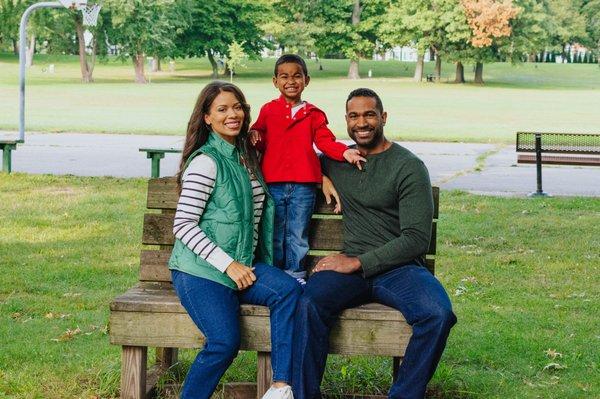 Family picture on a bench in the park.