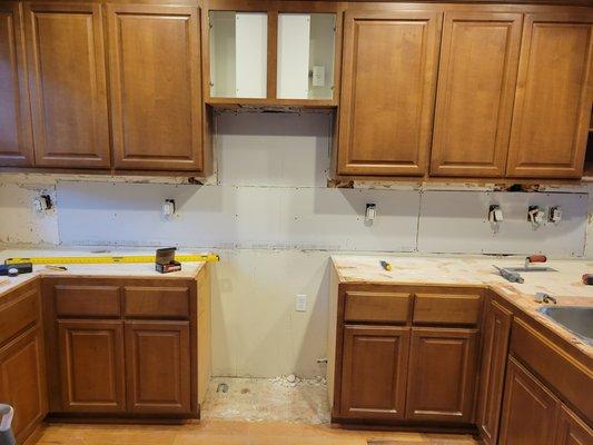 I replaced large sections of damaged drywall but the damage underneath the cabinets are difficult to handle.