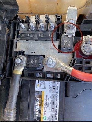 Car battery with broken fuse panel circled in red