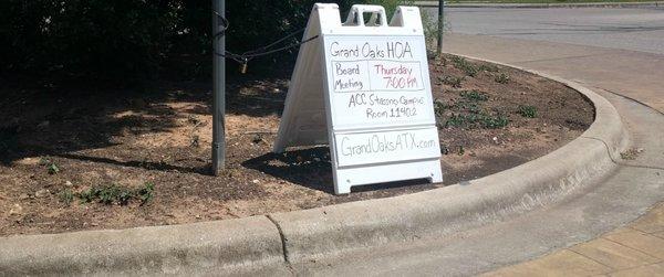 Sign near an entrance to Grand Oaks.   Plants at this traffic circle died 2 years ago.