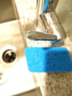 Appears to be dried soap on the handle of the kitchen sink faucet.