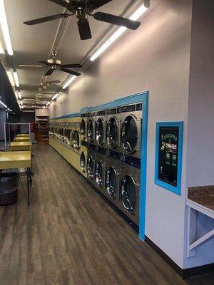 Picture of right side of laundromat from entrance which are the dryers.