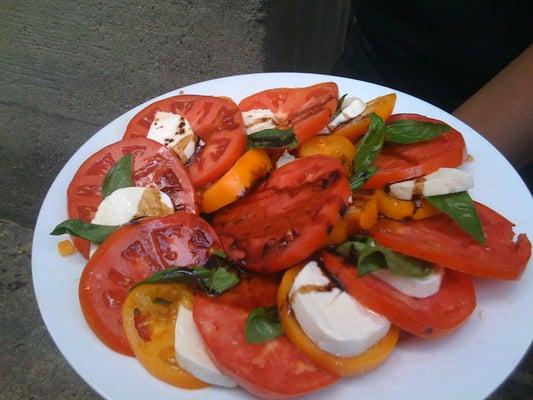 Mozzarella Caprese with red and yellow heirloom tomato, fresh mozzarella & basil, topped with laced balsamic reduction