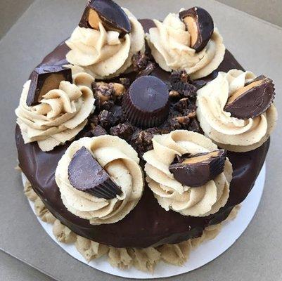 Chocolate cake with peanut butter frosting, topped with a chocolate ganache drip and finished with Justin's peanut butter cups