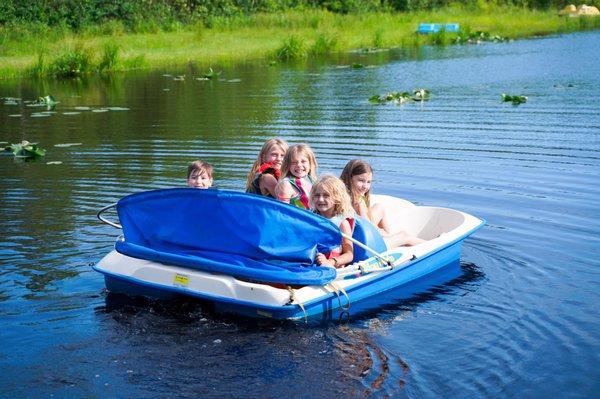 All the kids in one of the three ponds on a paddle boat having fun.