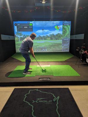 Man golfing on a simulator