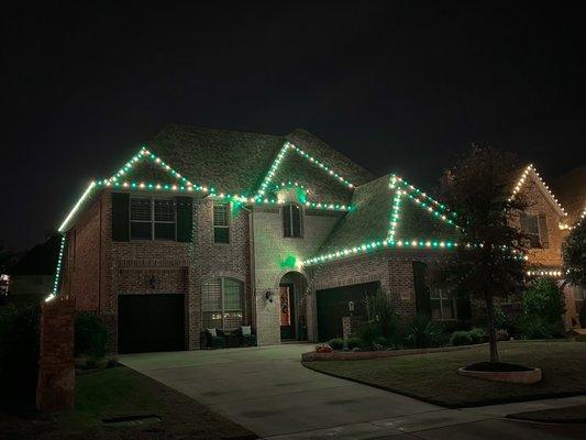 Christmas lights, green and warm white, full house with peak lights as well.