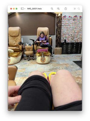 Lili who rushed through  my pedicure then sat on her phone.